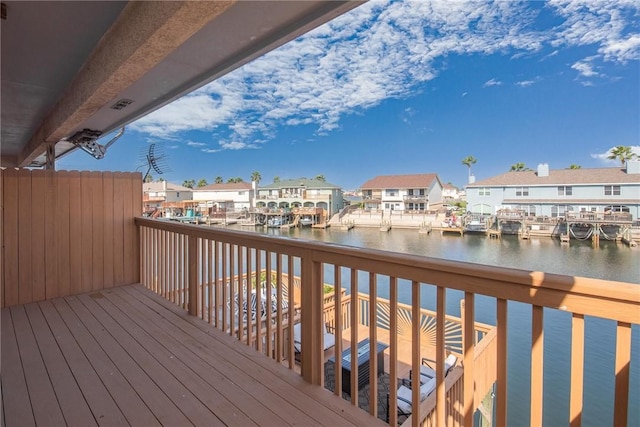 wooden deck with a residential view and a water view