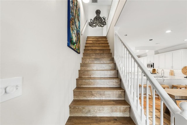 staircase featuring visible vents, wood finished floors, and recessed lighting