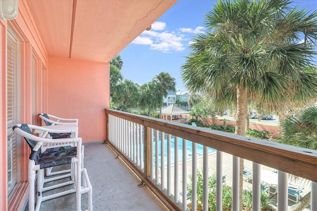 balcony featuring a view of the beach and a water view