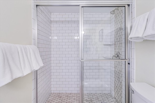 bathroom with toilet and a shower with door