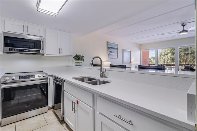 kitchen featuring white cabinetry, appliances with stainless steel finishes, sink, and light tile patterned floors