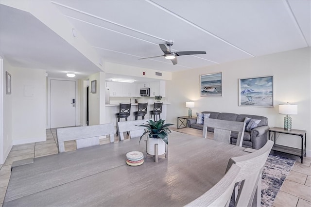 dining space featuring ceiling fan and light tile patterned floors