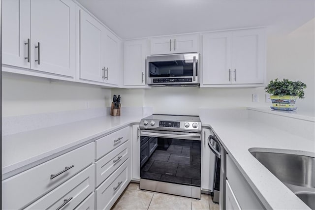 kitchen featuring white cabinets, light tile patterned floors, and stainless steel appliances