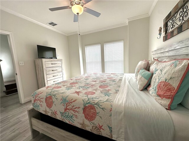 bedroom with light wood-type flooring, ceiling fan, and crown molding