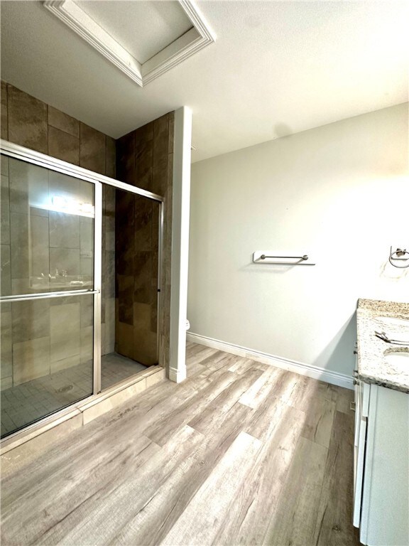 bathroom with toilet, a shower with door, hardwood / wood-style floors, vanity, and a raised ceiling