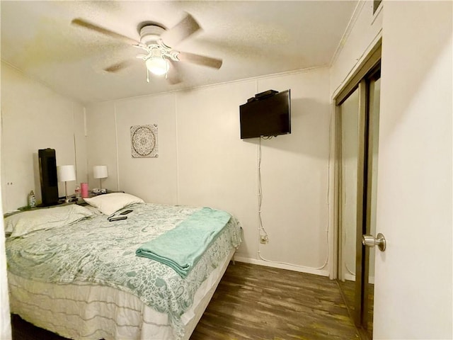 bedroom with dark hardwood / wood-style floors, ceiling fan, and crown molding