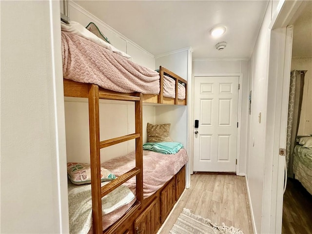 unfurnished bedroom featuring crown molding and light wood-type flooring