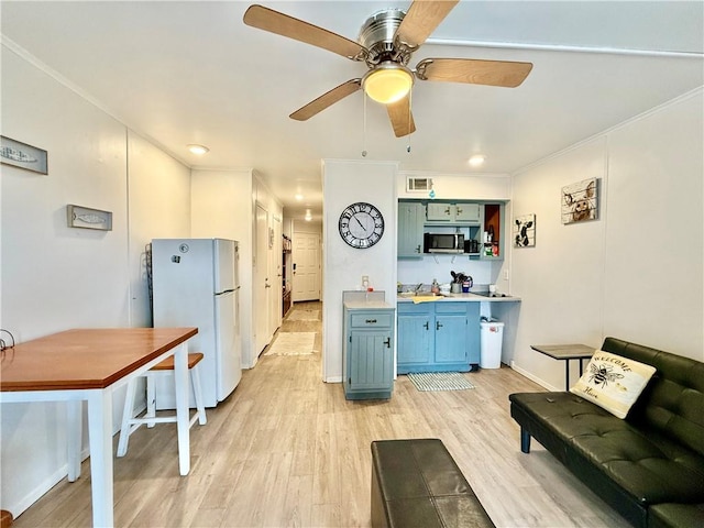 kitchen with ceiling fan, white refrigerator, crown molding, and light hardwood / wood-style flooring