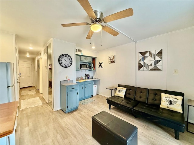 living room with ceiling fan, light hardwood / wood-style floors, and crown molding