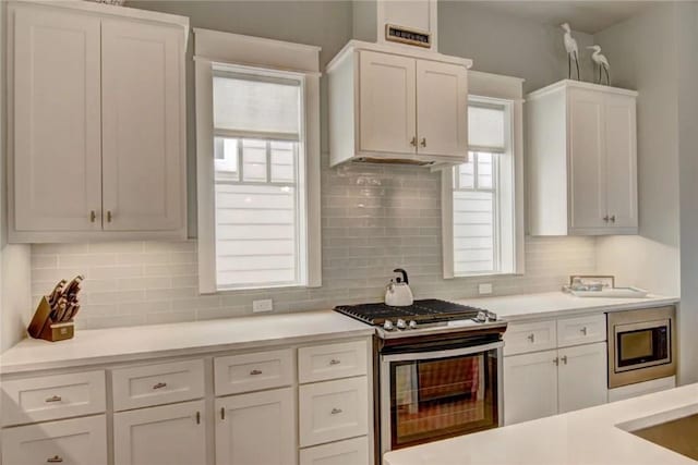 kitchen with white cabinets, stainless steel appliances, and tasteful backsplash