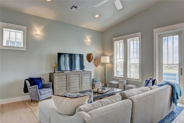 living room featuring ceiling fan, a healthy amount of sunlight, light wood-type flooring, and vaulted ceiling