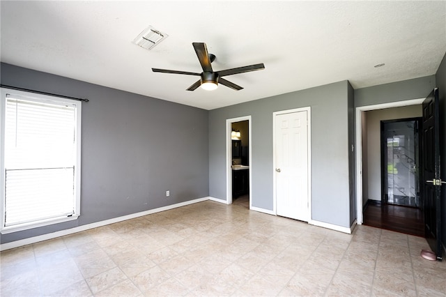 unfurnished bedroom featuring ceiling fan and ensuite bathroom