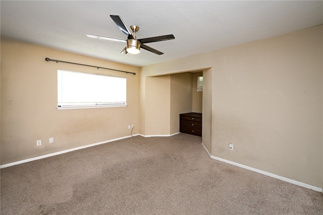 unfurnished bedroom featuring ceiling fan, a textured ceiling, and carpet