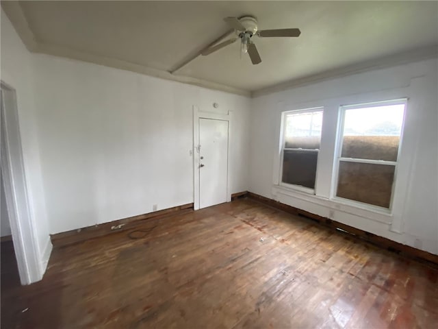 empty room featuring ornamental molding, ceiling fan, and dark hardwood / wood-style floors