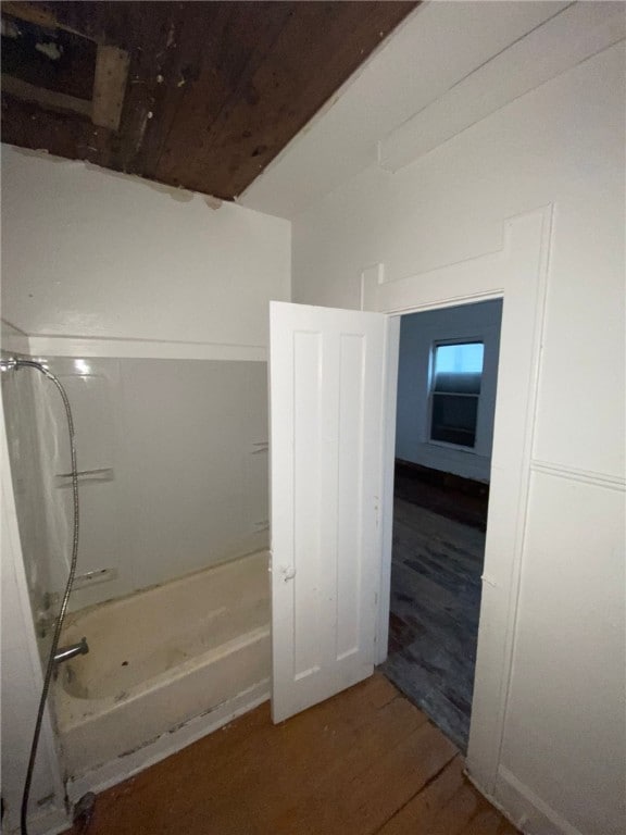 bathroom with hardwood / wood-style floors and shower / washtub combination