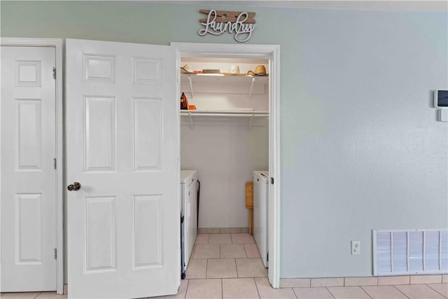 laundry area with light tile patterned floors and washing machine and clothes dryer