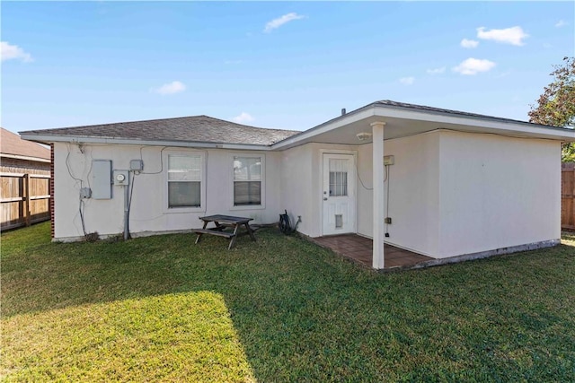 rear view of house with a patio area and a yard