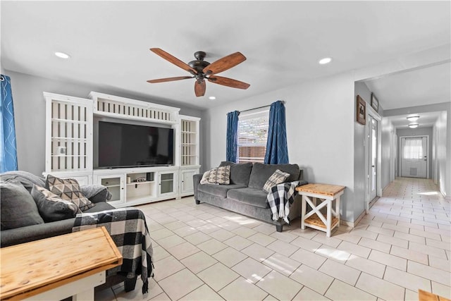 tiled living room with ceiling fan and plenty of natural light