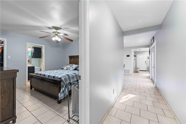 bedroom featuring ceiling fan, light tile patterned floors, and a spacious closet