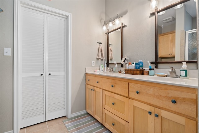 bathroom featuring vanity, a shower with shower door, and tile patterned flooring