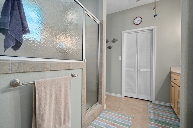 bathroom featuring tile patterned flooring, vanity, and a shower with door