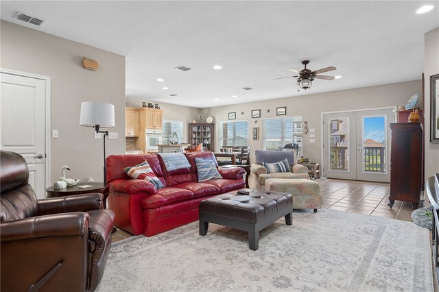 tiled living room with french doors and ceiling fan