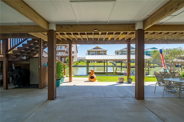 view of patio featuring a grill, stairs, and a water view