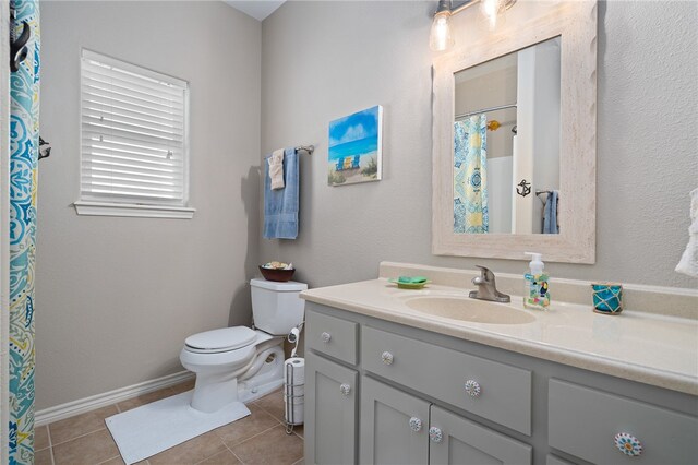 bathroom featuring vanity, tile patterned floors, and toilet