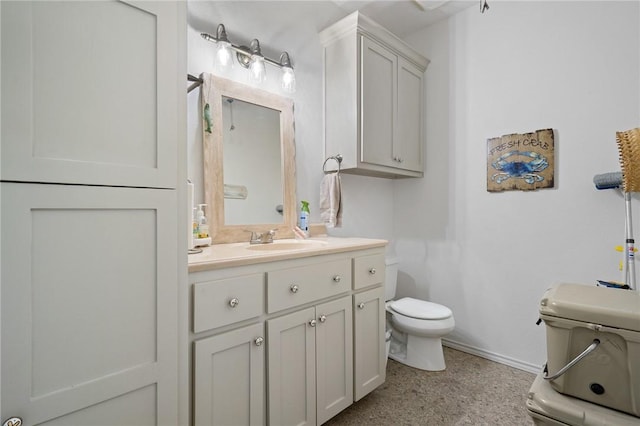 bathroom featuring baseboards, toilet, and vanity