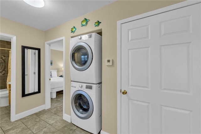 washroom featuring light tile patterned flooring and stacked washer / dryer