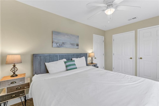 bedroom featuring ceiling fan and multiple closets