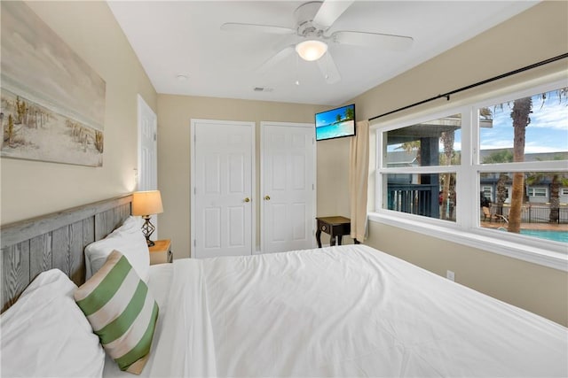 bedroom featuring ceiling fan and two closets