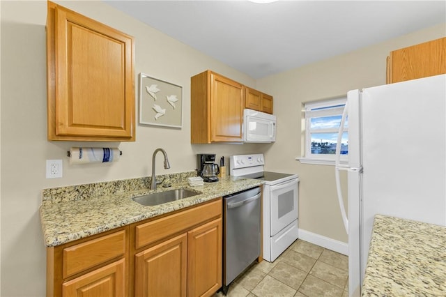 kitchen featuring light tile patterned floors, sink, light stone counters, and white appliances