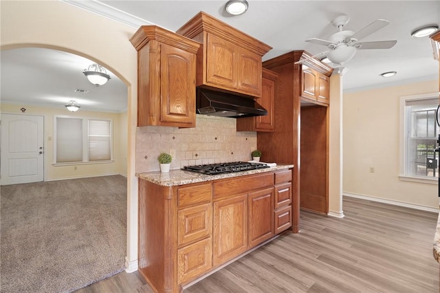 119 N Rife St, Aransas Pass, TX 78336 - kitchen with black gas cooktop, arched walkways, a ceiling fan, baseboards, and crown molding