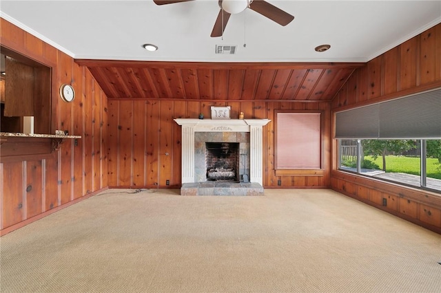 119 N Rife St, Aransas Pass, TX 78336 - unfurnished living room with carpet, wooden walls, a tiled fireplace, and ceiling fan