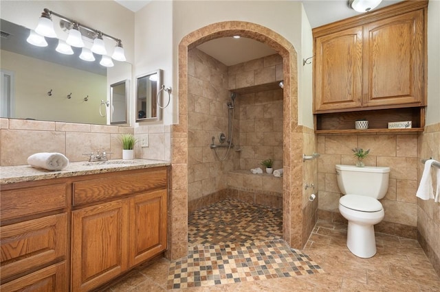 119 N Rife St, Aransas Pass, TX 78336 - full bathroom featuring tile walls, walk in shower, toilet, vanity, and tile patterned flooring