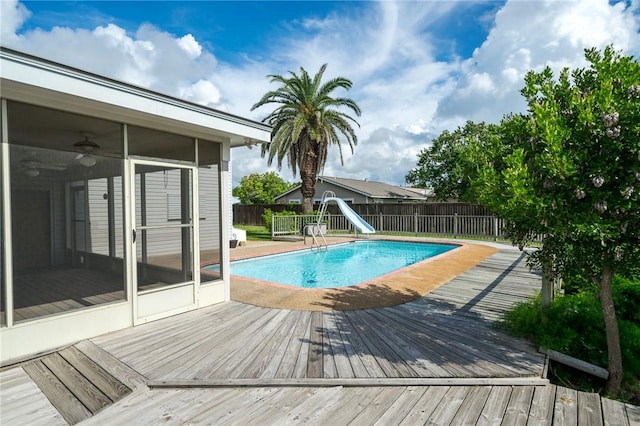 119 N Rife St, Aransas Pass, TX 78336 - view of swimming pool featuring a water slide, a sunroom, a wooden deck, and a fenced backyard