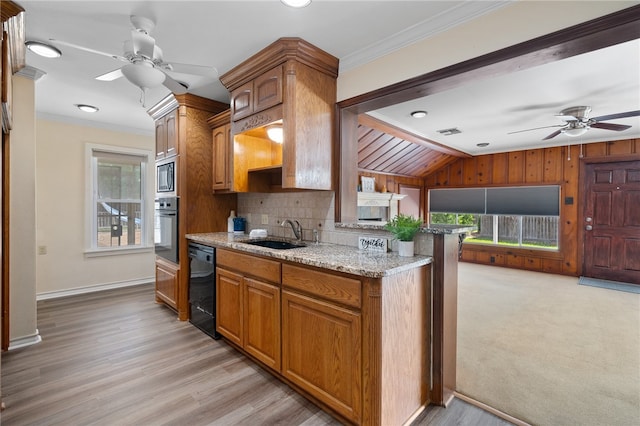 kitchen with stainless steel appliances, wooden walls, sink, and ornamental molding