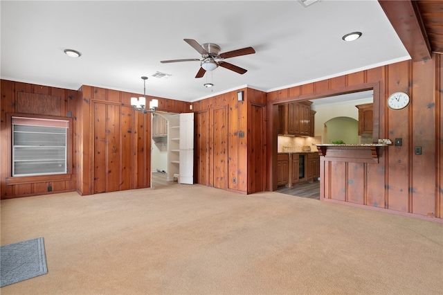 living room featuring ornamental molding, light colored carpet, and wood walls