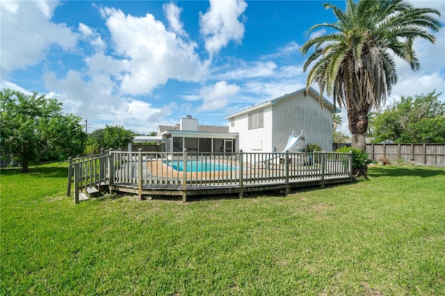 view of swimming pool with a lawn and a wooden deck