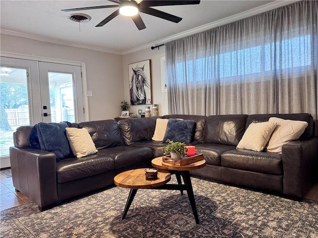 tiled living room with crown molding, ceiling fan, and french doors