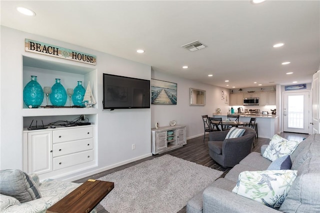 living room with dark wood-style floors, baseboards, visible vents, and recessed lighting