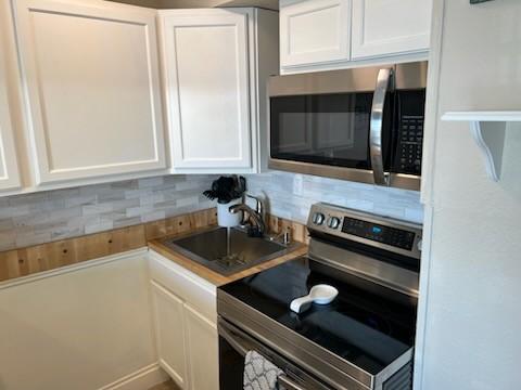 kitchen featuring sink, stainless steel appliances, and white cabinets