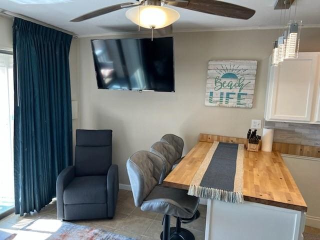 office area featuring light tile patterned floors, ceiling fan, and ornamental molding