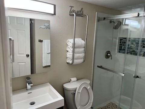 bathroom with vanity, a shower with shower door, and toilet