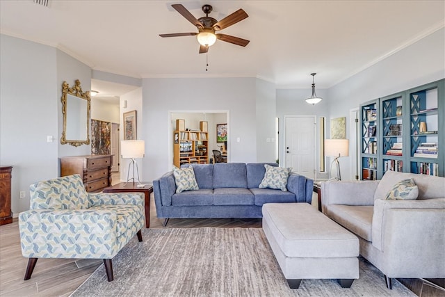 living room with hardwood / wood-style flooring, crown molding, and ceiling fan