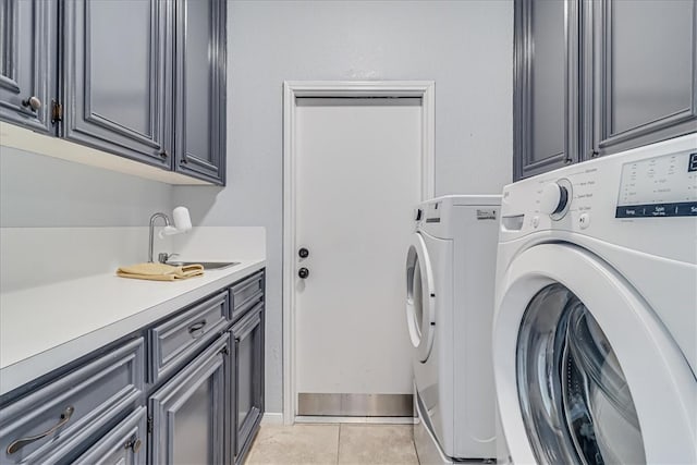 washroom featuring separate washer and dryer, cabinets, sink, and light tile patterned floors