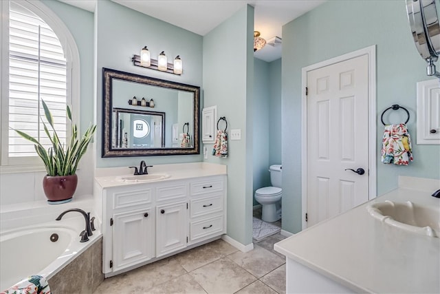 bathroom featuring toilet, vanity, tile patterned flooring, and tiled tub