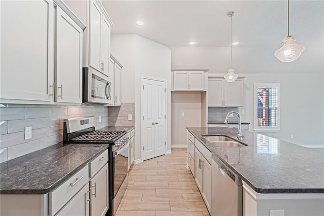 kitchen featuring pendant lighting, white cabinetry, stainless steel appliances, and sink