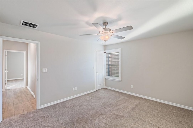 carpeted spare room featuring ceiling fan